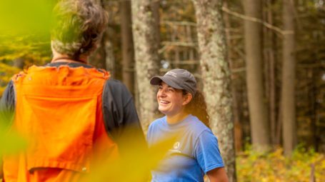 woman laughing talking to man in wooded setting