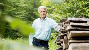 Bob Hoffman standing by woodpile on his property