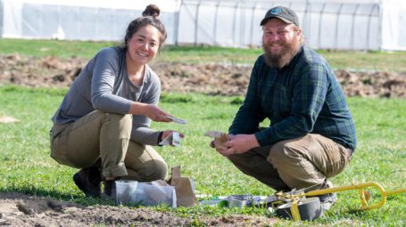 Gabby and Henry planting seeds at Old Road Farm in Granville