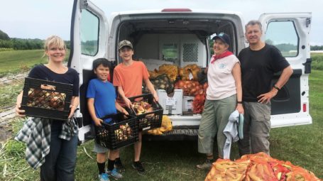 group of people with corn and onions after a glean on a vermont farm