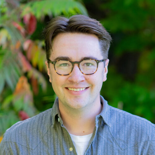 you man wearing glasses smiling at camera