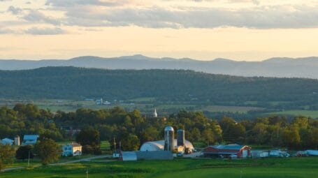 early morning landscape view of Weybridge Vermont with Monument Farms in the foreground and mountains in the back