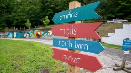 Signs point to animals, trails, north barn, and market