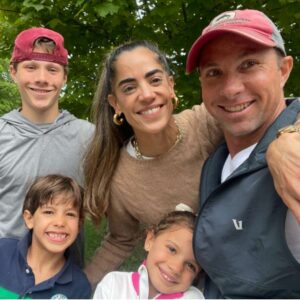 A smiling family selfie with a dad, mom, and three kids.