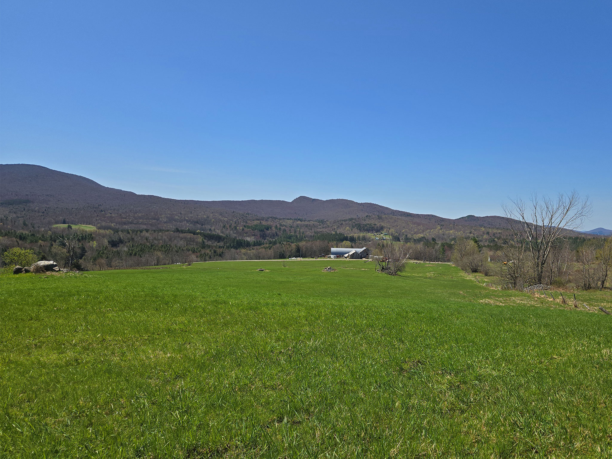 A farm field with mountains in the background