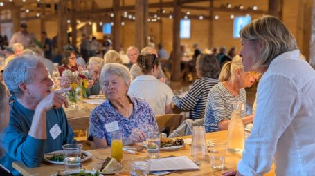 People speak around a table at an event.