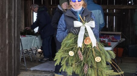An event participant poses with her evergreen swag.
